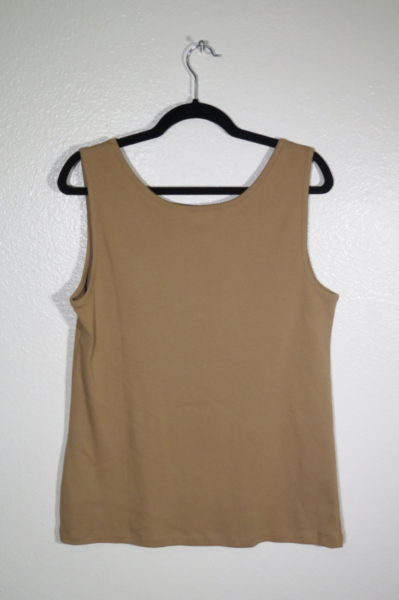 back view of brown tank top on hanger hanging on a nail against a white wall.