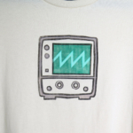 medium closeup of the block print of an oscilloscope displaying a sawtooth waveform hand printed centered over the chest area of the t-shirt.