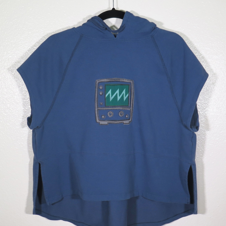 A navy sleeveless hooded shirt on a hanger hangs on a nail against a white wall. Showing the front. A block print of an oscilloscope with a sawtooth waveform displayed is hand printed in the center. The hoodie strings are pulled back to show the print more.