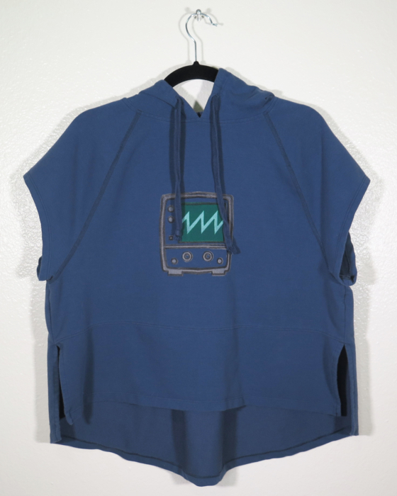 A navy sleeveless hooded shirt on a hanger hangs on a nail against a white wall. Showing the front. A block print of an oscilloscope with a sawtooth waveform displayed is hand printed in the center.