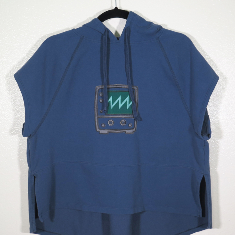 A navy sleeveless hooded shirt on a hanger hangs on a nail against a white wall. Showing the front. A block print of an oscilloscope with a sawtooth waveform displayed is hand printed in the center.