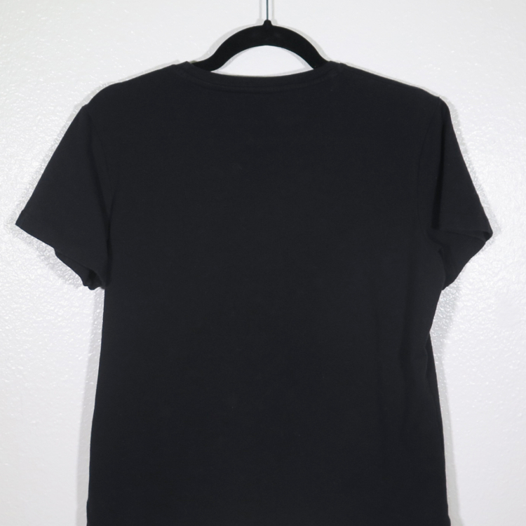 back of black t-shirt on hanger hanging on a nail against a white wall. It is hand printed with an LED design